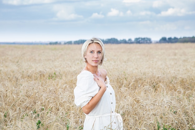 Schönes blondes Mädchen in einem Weizenfeld