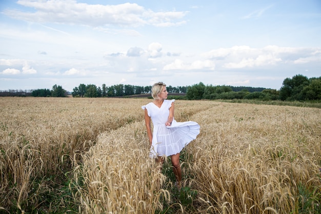 Schönes blondes Mädchen in einem Weizenfeld