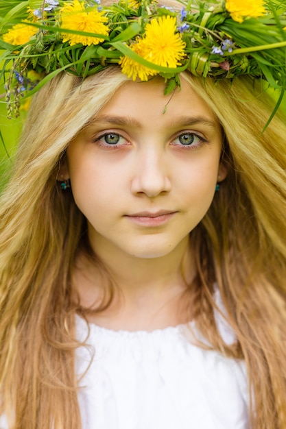 Schönes blondes Mädchen mit einem Blumenkranz