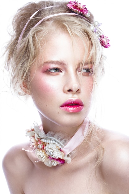 Schönes blondes Modemädchen mit Blumen auf Hals und in ihrem Haar, nasses nacktes Make-up