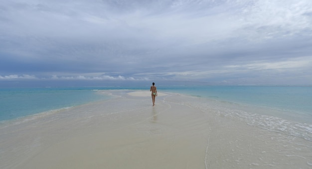 Schönes brünettes Mädchen in einem grünen Bikini auf einer tropischen Insel