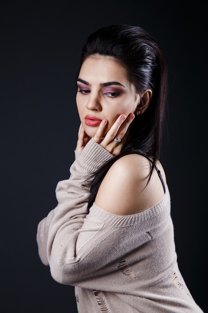 Schönes Brunettemädchen in der beige Strickjacke