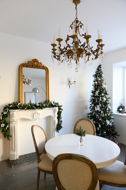 Schönes, dekoriertes Zimmer mit Weihnachtsbaum mit Geschenken darunter