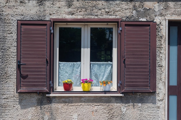 Schönes Fenster mit Blumen in einem alten mittelalterlichen Haus in Süditalien