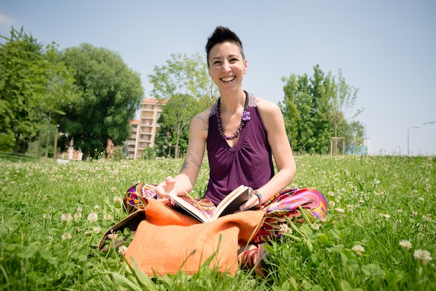 schönes Frauenlesebuch des Hippie-kurzen Haares im Park