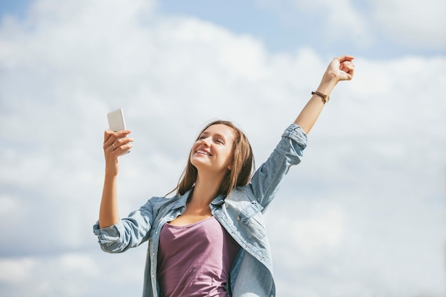 Schönes Frauenmodell mit Handy-Smartphone draußen