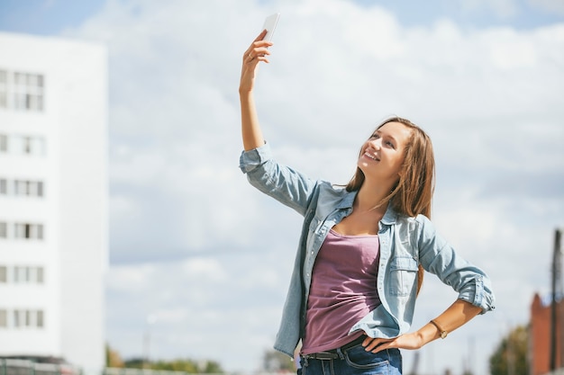 Schönes Frauenmodell mit Handy-Smartphone draußen