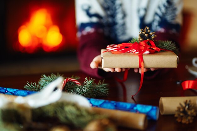 Schönes Geschenk in den Händen der Männer Neujahrsgeschenk mit einer roten Schleife auf dem Tisch