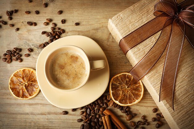 Schönes Geschenk, Tasse mit Kaffee und Kaffeebohnen auf Holzuntergrund