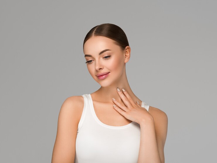 Schönes Hautfrauenmodell mit den Händen. Natürliche Make-up Schönheit Gesicht rosa Lippen. Hintergrundfarbe grau