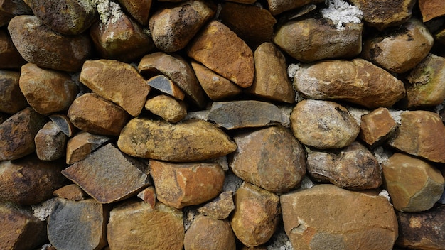 Schönes Hintergrundbild mit Muster einer Wand aus runden Steinen in roter Farbe Felsen Textur