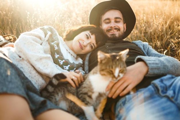 Schönes Hipster-Paar mit Katze Paar mit schönen Hüten und Pullovern Lifestyle