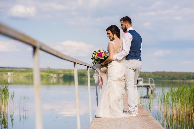 Schönes Hochzeitspaar, das am Rande umarmt