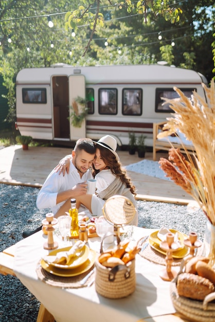 Schönes Hochzeitspaar lacht und küsst sich beim Camping im Wohnmobil in einem romantischen Moment