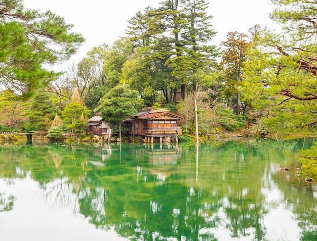 Foto schönes holzhaus am rande eines teiches in einem schattigen garten im japanischen stil.