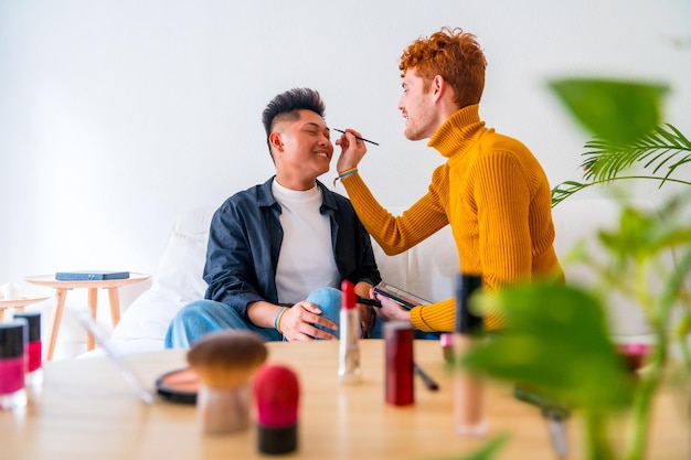 Schönes homosexuelles paar, das make-up macht und spaß hat, romantisch zu hause lgbt-konzept zu sein