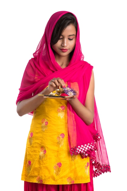 Schönes indisches junges Mädchen, das pooja thali hält oder Anbetung durchführt