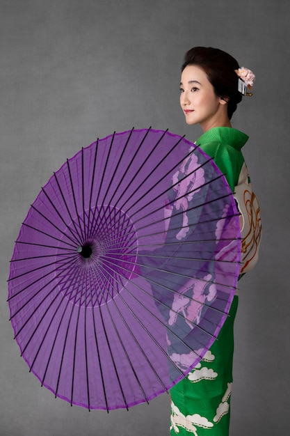Schönes japanisches Model mit lila Regenschirm