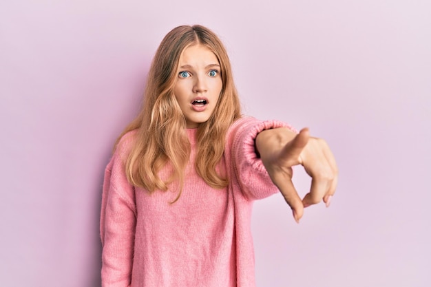 Foto schönes junges kaukasisches mädchen, das lässige kleidung trägt, die mit dem finger zeigt, überrascht nach vorne, offener mund, überraschter ausdruck, etwas auf der vorderseite