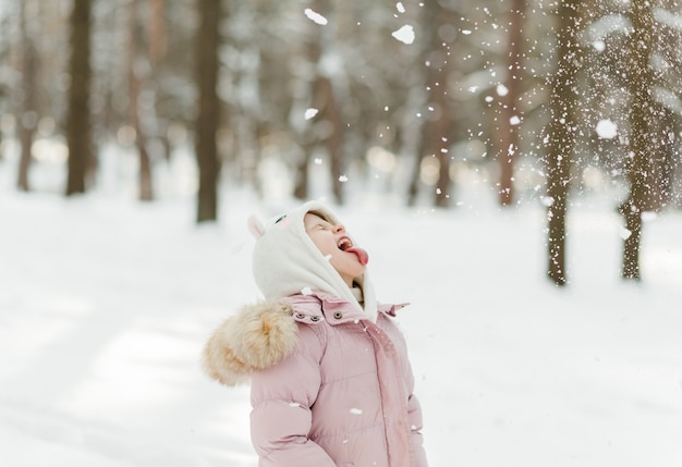 Schönes junges Mädchen, das den Winter im Freien genießt Hübsche Frauen, die Spaß haben und lächeln