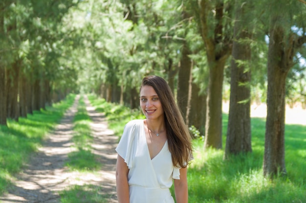 Schönes junges Mädchen, das im Bauernhofwald in die Kamera lächelt