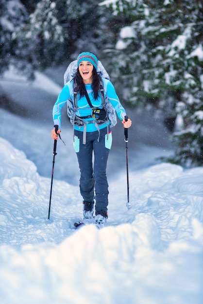 Schönes junges Mädchen, das Skitouren in den Wäldern übt