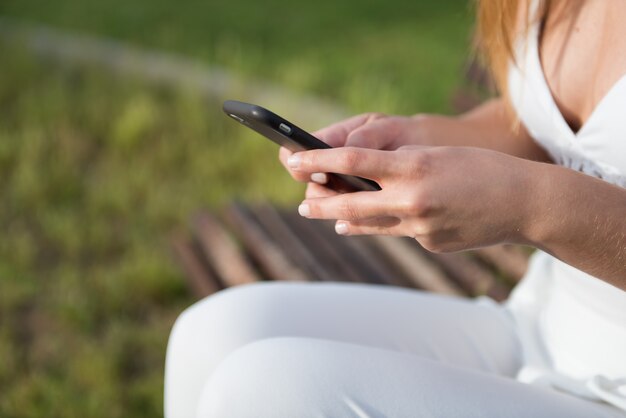 Foto schönes junges mädchen in einem park sprechend mit mobile