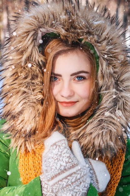 Schönes junges Mädchen in einem Winterwald Winterporträt von Frauen in Fäustlingen und Schal