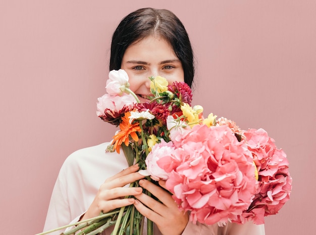 Schönes junges Mädchen mit einem großen rosa Blumenstrauß