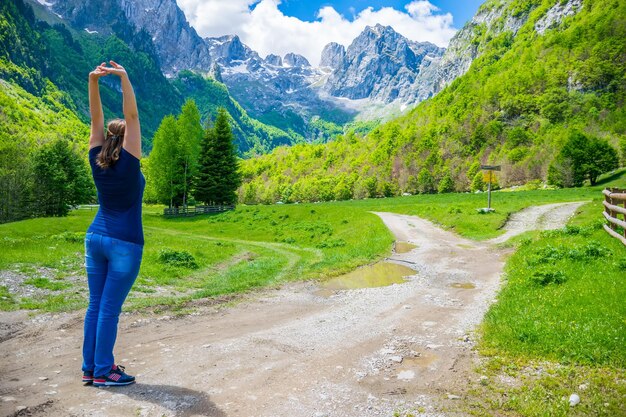 Schönes junges Mädchen posiert vor dem Hintergrund hoher schneebedeckter Berge