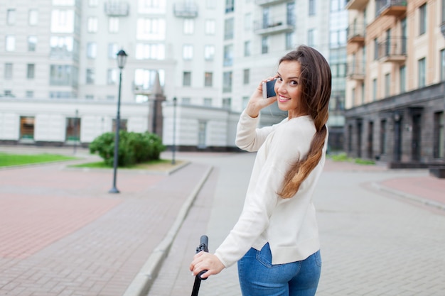 Schönes junges Mädchen sprechen mit einem Freund am Telefon.