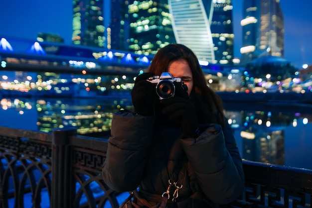 Schönes junges Mädchen steht auf dem Hintergrund der Moskauer Stadt im Winter
