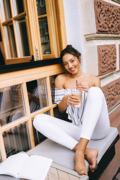 schönes junges Mädchen, trinken Kaffee in der Stadt