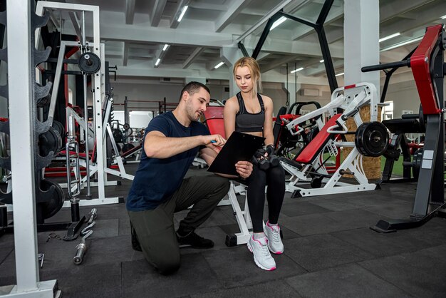 Schönes junges Paar aus Mann und Frau trainiert im Fitnessstudio, um sich fit zu halten