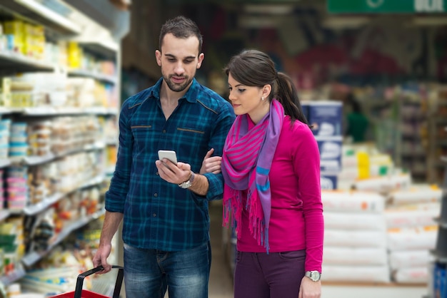 Schönes junges Paar Einkaufen für Obst und Gemüse im Produzieren Abteilung eines Supermarktes Supermarkt seichte Tiefe des Feldes