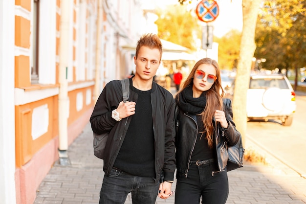 Schönes junges Paar in der trendigen Kleidung mit Taschen, die zusammen in der Stadt reisen