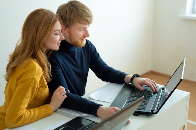 schönes junges Paar Mann und Frau, die am Laptop arbeiten