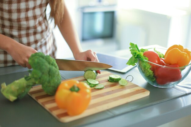 Schönes junges Paar schaut sich an und lächelt beim Kochen in der Küche zu Hause.