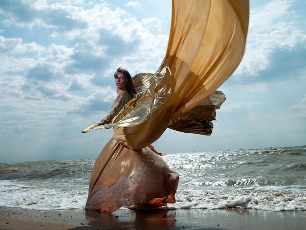 Schönes junges sexy Model in einem schicken Kleid am Strand