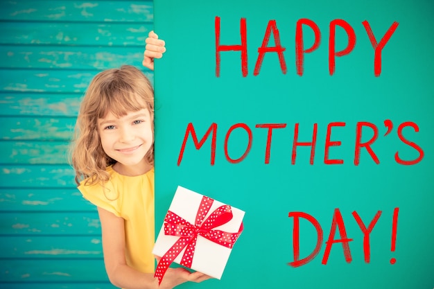 Schönes Kind mit Geschenk versteckt sich hinter Banner leer Frühling Familienurlaub Konzept Muttertag