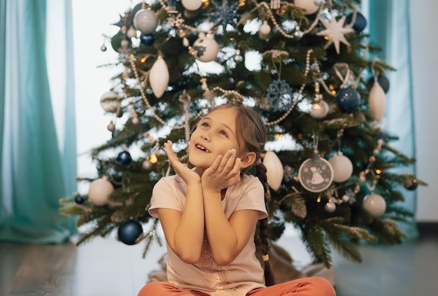 Schönes Kindermädchen nahe einem Weihnachtsbaum. Weihnachtskonzept.