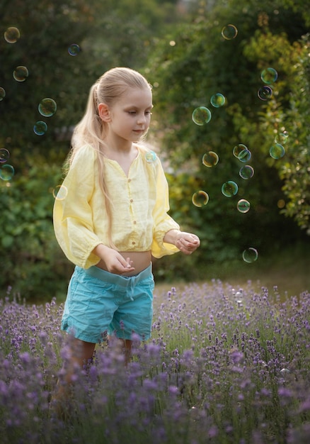 Schönes kleines Mädchen auf einem Gebiet mit Lavendel