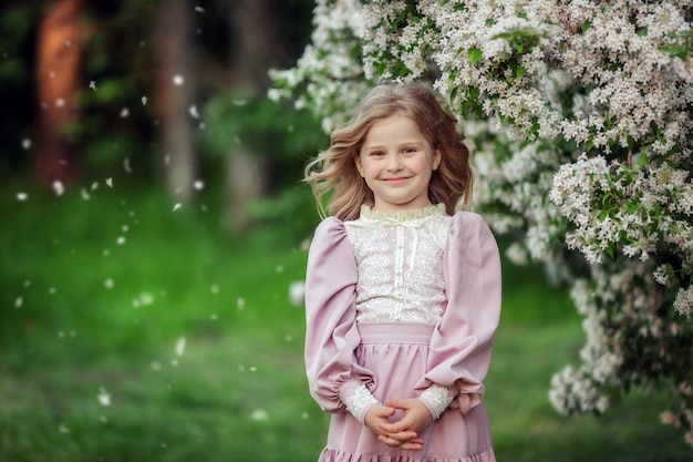 Schönes kleines Mädchen in einem blühenden Park