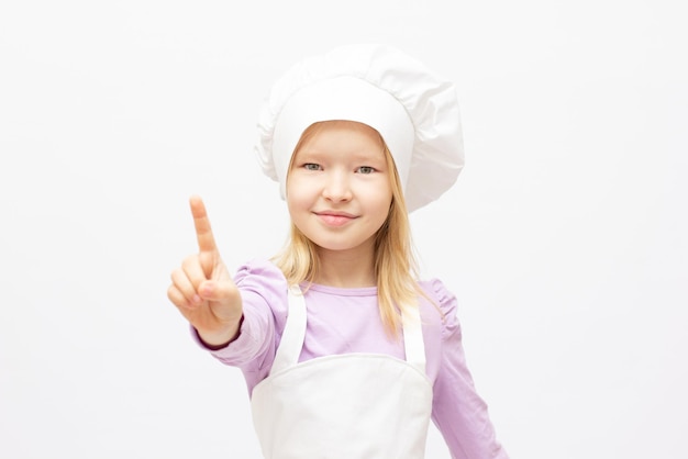 Schönes kleines Mädchen in Kochuniform, isoliert auf weiss