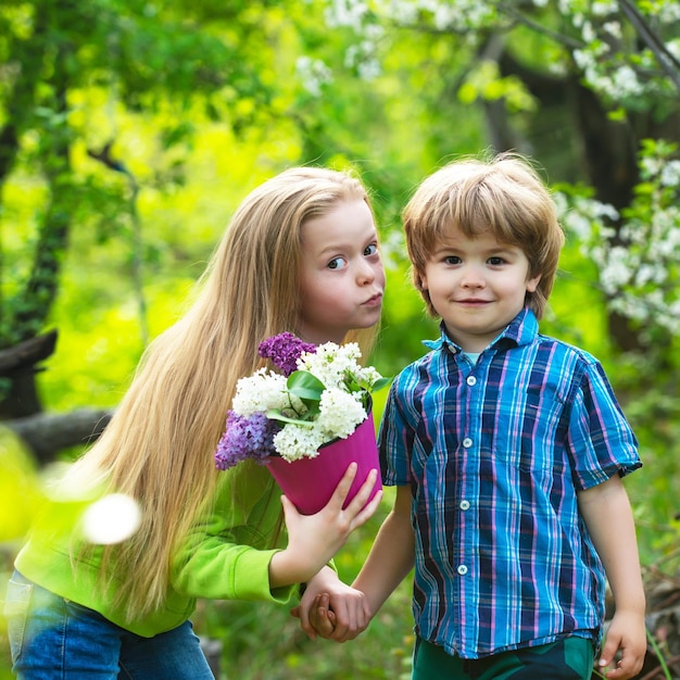 Schönes kleines Mädchen küsst den Jungen zärtlich in seine Wange, erste Liebe und Kindheitskonzept, schöne Kinder