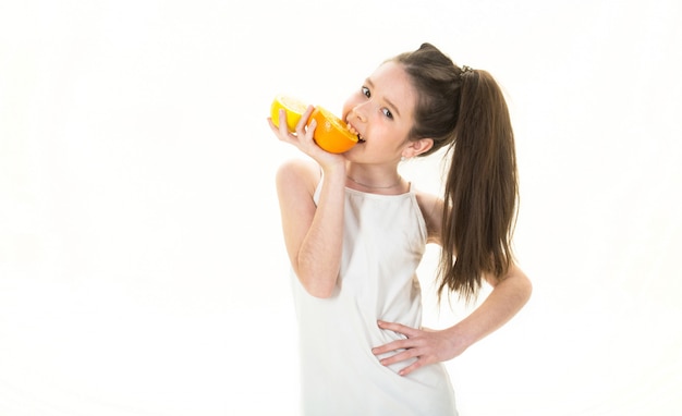 Schönes kleines Mädchen mit Orangen, Zitronen, Grapefruits, Vitamin. Baby, das eine große saftige Orange hält.