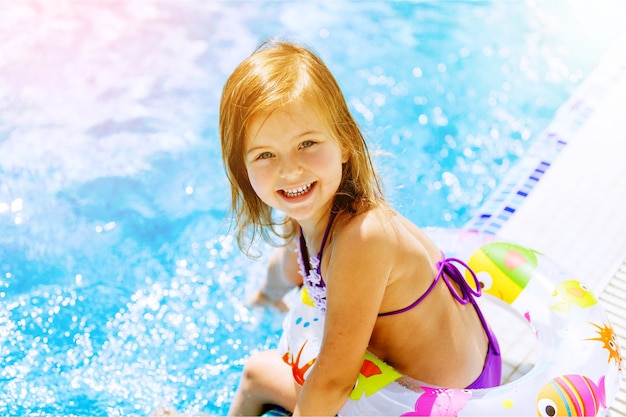 Foto schönes kleines mädchen sonnt sich am pool