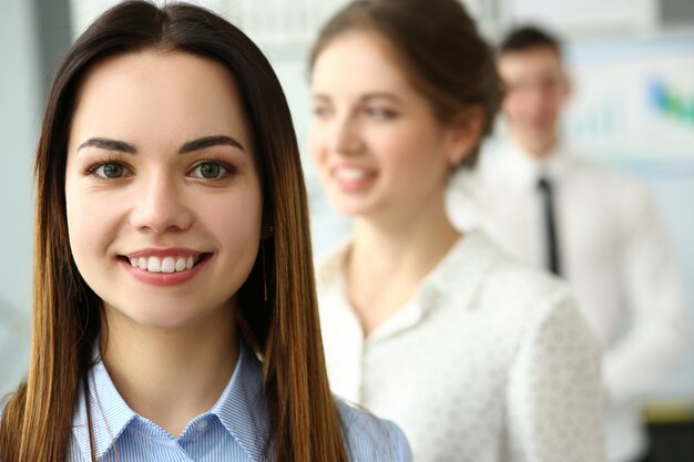 Schönes lächelndes brünettes Schreibermädchen am Arbeitsplatz