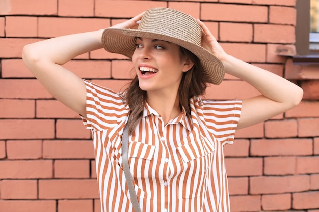 Schönes lächelndes Brunettemodell kleidete in der Sommerhippie-Kleidung an. Lustige und positive Frau, die Spaß hat.