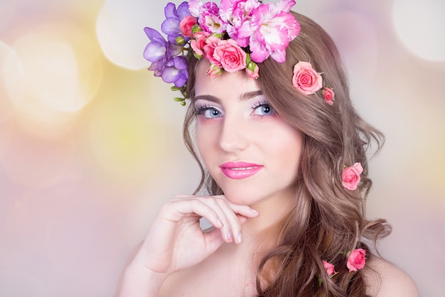 Schönes lächelndes Mädchen mit Blumen in ihrem Haar